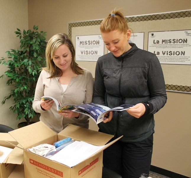 Jocelyn O&#8217;Neill (left) and Amanda MacArthur of école John Wilson Elementary School look at books to be used in their Daily Five teaching strategies.