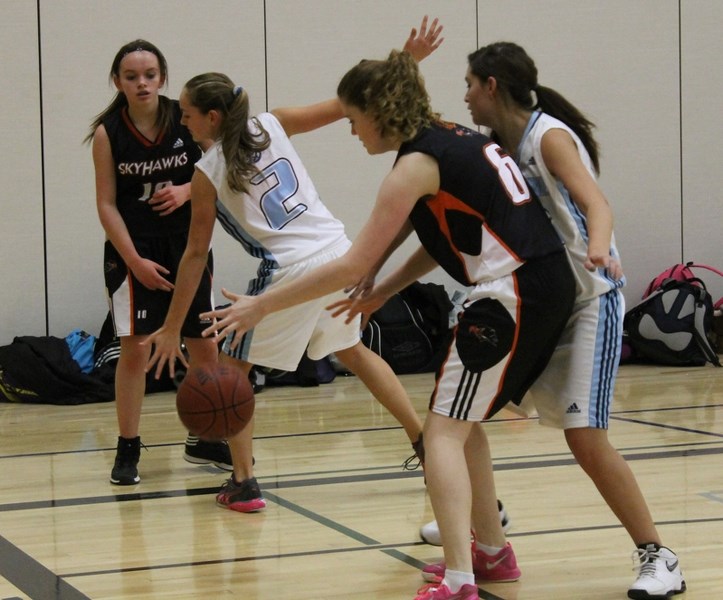 Penhold Skyhawks players pass the ball under the hoop during their first basketball game in Penhold Crossing Secondary School history on Dec. 10.