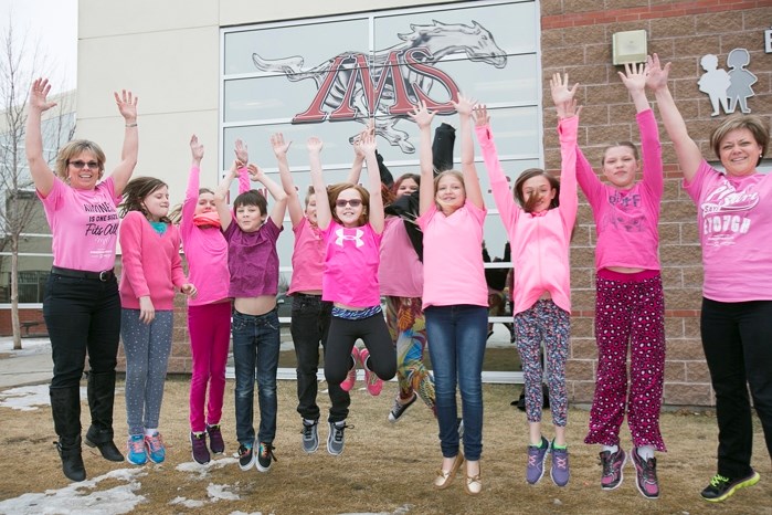 PINK KINDNESS &#8211; Innisfail Middle School teacher Tanis Klymyk, left, and education assistant Kari Fox, right, with a group of Grade 5 students wearing pink shirts on