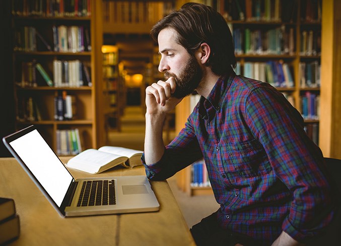 Hipster student studying in library at the university