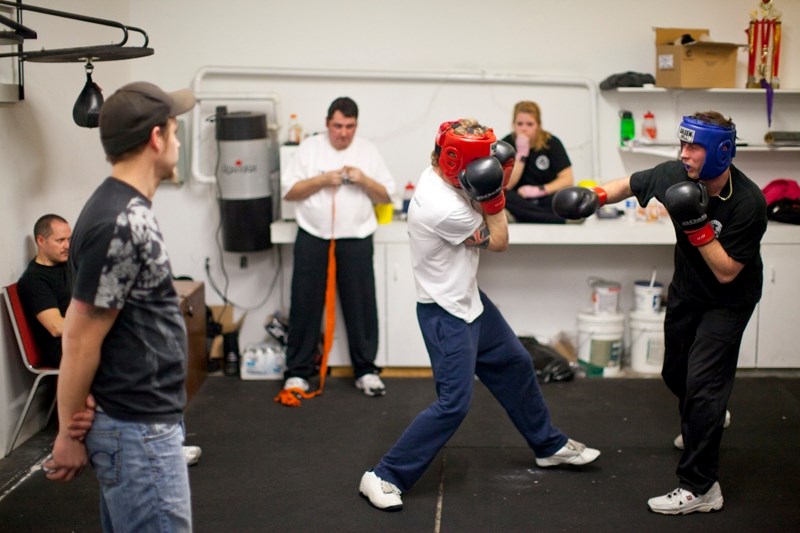 Clayton Braun, middle and Wayne Pike spar while Tim Bowen(L), Lindsay Walsh, Darin Quantz and Sherry Payne watch at the Olds Boxing Club recently.