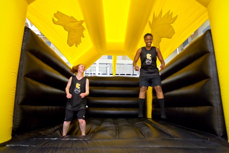 Jerri-lyn Chisholm, left, and Tracy Frimpong ham it up in an inflatable bouncer at the Ralph Klein Centre.