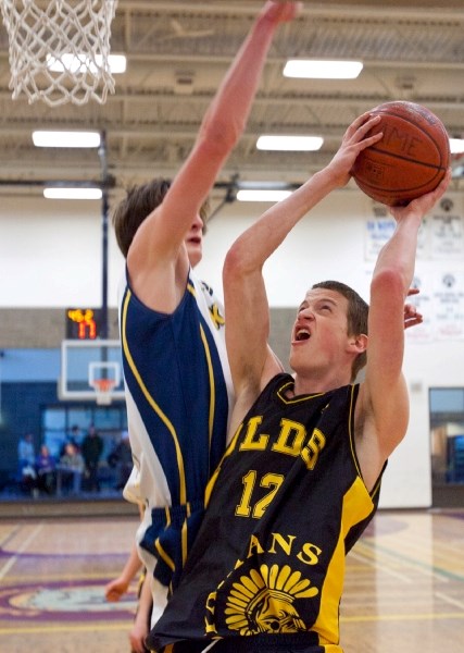 Olds Spartans forward Justin Ibsen takes the ball up against a Carstairs defender during last week&#8217;s league semi-final in Didsbury.