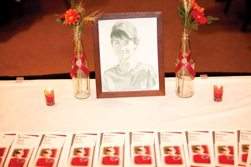 A picture of slain Olds College student Nicholas Baier sits on a table at the Alumni Centre surrounded by pamphlets intended to stir interest in an endowment fund established 