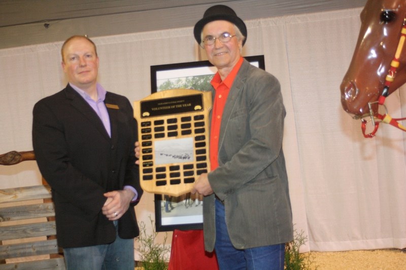 Curtis Flewelling, president of the Olds Agricultural Society, presents Joe Halerewich with the OAS volunteer of the year plaque on Saturday at the annual chautauqua.