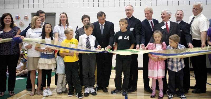 Premier Ed Stelmach cuts a ribbon opening Holy Trinity School during a ceremony last week, assisted by Red Deer Regional Catholic school division officials.