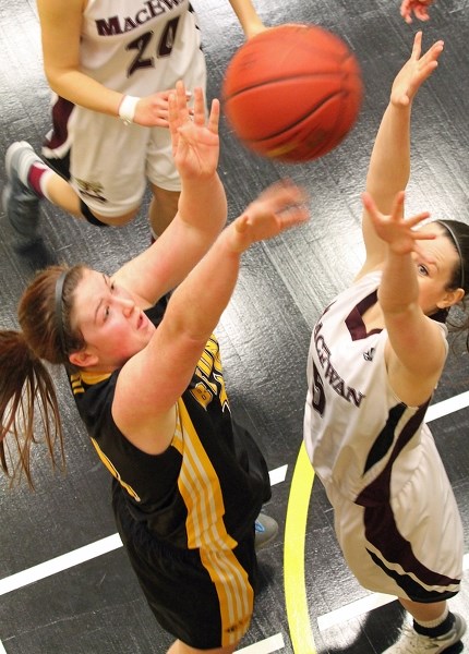 Thera Melanie, a forward for the Olds College Broncos women&#8217;s basketball team, tries to get a shot past Lauren Parker of the Grant MacEwan Griffins in the fourth