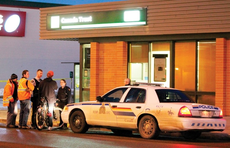 Police speak to witnesses outside the TD Canada Trust on 50 Avenue after a man allegedly robbed the bank after 5 p.m. on Jan. 24. CLICK ON PICTURE FOR LARGER IMAGE