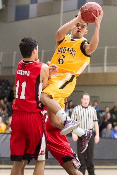 Olds College Broncos junior varsity player Julius Rara passes the ball on a drive to the hoop during the Broncos&#8217; game against the CUC Aurora at the Ralph Klein Centre