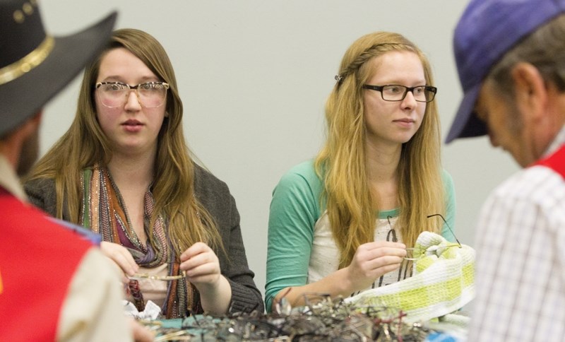 Sundre High School students Darbie Sadoway, left, and Sandra Block sort through eyeglasses at the Olds Evergreen Centre on Feb. 8. CLICK ON PHOTO FOR LARGER IMAGE