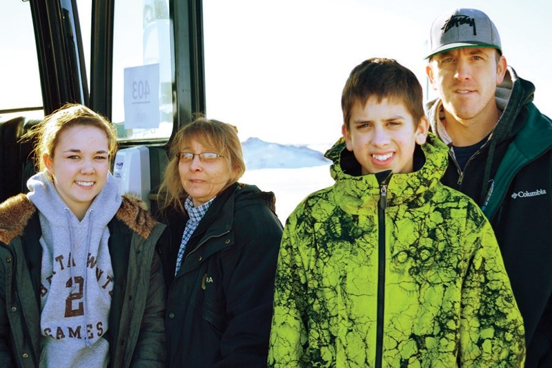 From left to right: Rachelle Fullerton-Lee, Rhonda Fullerton-Lee, Austin Mitchell and Dave Mitchell wait for a bus at the Olds Cardlock on Feb. 6.