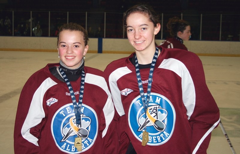Alayna Wagstaff (left) and Paige Grenier show off the gold medals they won as part of the Zone 2 girls hockey team at the Alberta Winter Games. The Zone 2 team went