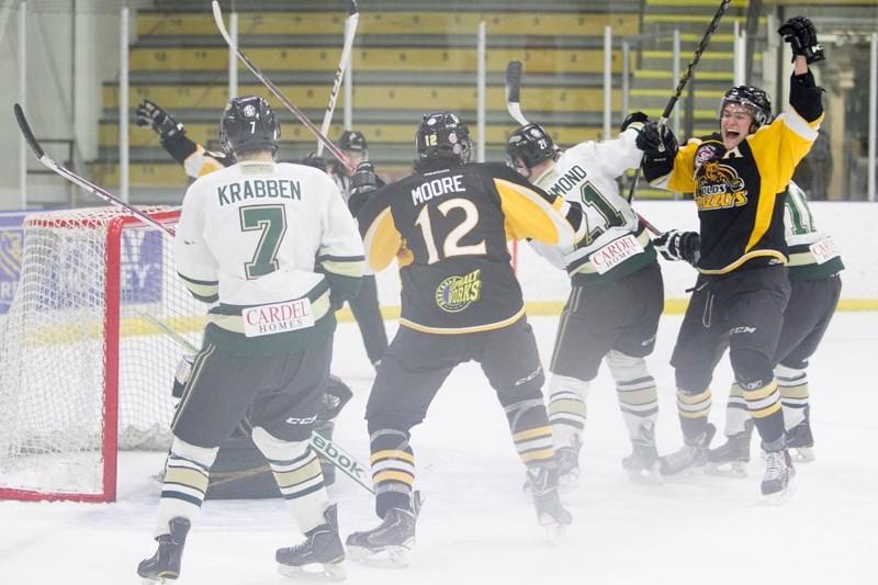 Members of the Olds Grizzlys celebrate after a power-play goal by Austin Kernahan, right, late in the second period of the Grizzlys&#8217; game against the Okotoks Oilers at