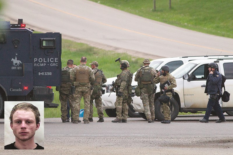 Police gear up at a command post near the interchange of highways 2 and 587 on the evening of June 12 to search for a fugitive believed to be hiding in a flower nursery north 
