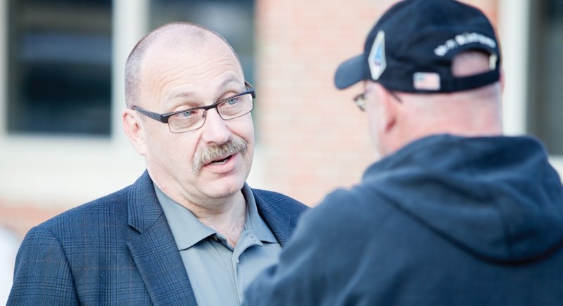 Alberta Progressive Conservative Party leadership candidate Ric McIver speaks with an Olds resident during a tour through Olds on June 11.