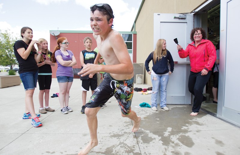Grade 5 student Caleb Trotter runs out of the Olds Aquatic Centre pool to tag off his partner for the bike section of the Ecole Deer Meadow School&#8217;s annual triathlon on 