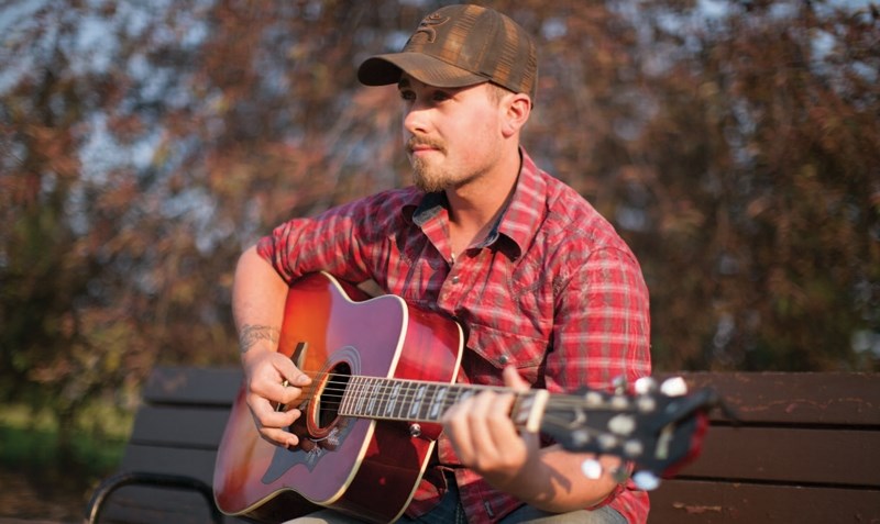 Ryan Notley plays his guitar at Centennial Park on July 10. CLICK ON PHOTO FOR LARGER IMAGE