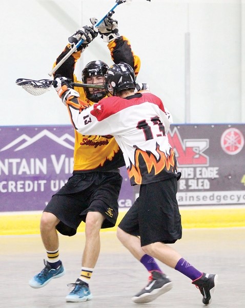Cale Brown of the Olds Stingers (left) battles with High River Heat player Dustin Tolhurst during the teams&#8217; final regular season meeting in Olds on July 13. Olds won