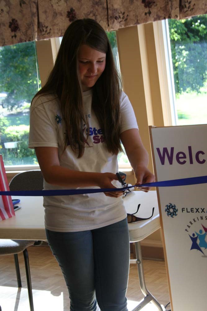 Emma Zwart of Olds cuts the ribbon during the Flexxaire Parkinson Step &#8216;n Stride fundraising walk in Red Deer.