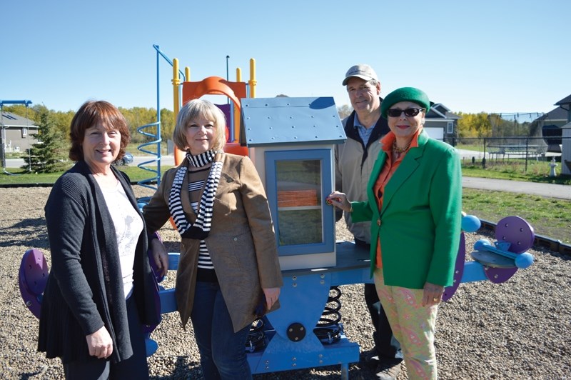 From left, Jeanne Richardson, Yvonne Moore, Dave Heilman and Olds mayor Judy Dahl display Olds&#8217; first Little Free Library at a playground on Briegel Road on Oct. 1.
