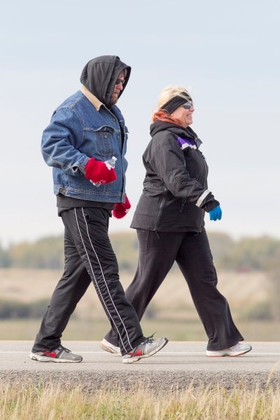 Daniel Trudell and Margaret Sheffield walk on Hwy. 2A during Trudell&#8217;s three-day walk from Olds to Red Deer on Oct. 3. Trudell, a stroke survivor, was walking to raise