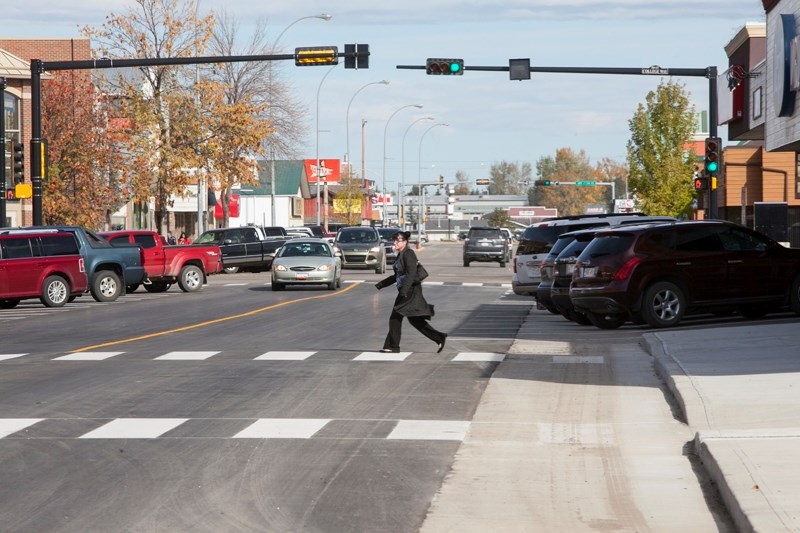 CONSTRUCTION COMPLETED &#8211; &lt;br /&gt;A pedestrian walks across a newly installed crosswalk along 50th Avenue in Uptowne on Oct. 6.