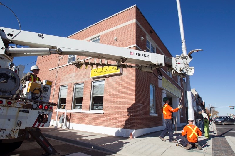 Workers install a light standar at the corner of 50 Street and 51 Avenue on Oct. 8.