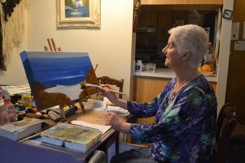 Artist Marie Paterson works on her latest painting, entitled The Oregon Coast.