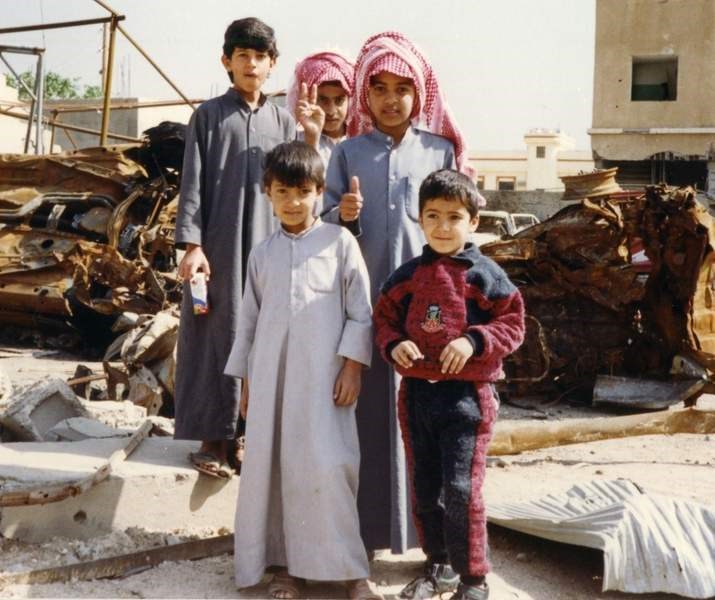Middle Eastern youth pose amid the rubble in their community.