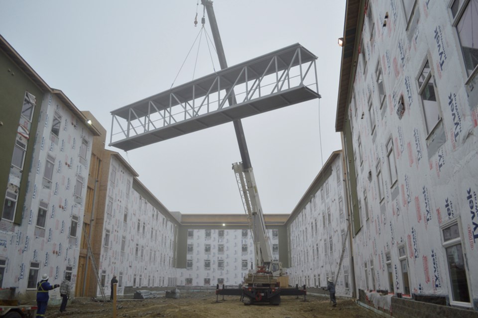 Construction crews at Olds College hoist the Centennial Village bridge for installation on Oct. 30. The bridge is about 21 metres long and will be accessed from the third