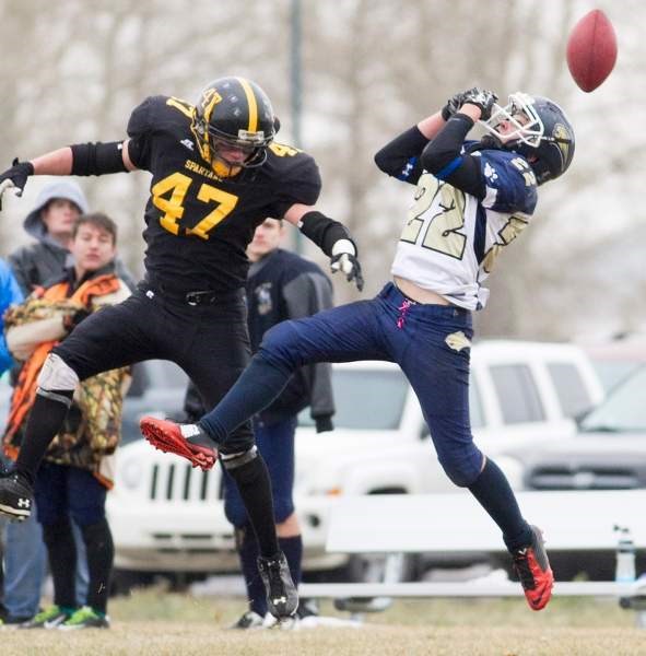 Olds High School Spartans player Ryland Couture strips the ball while tackling a Bow Valley player during the Spartans game against the Bow Valley Bobcats at Normie Kwong