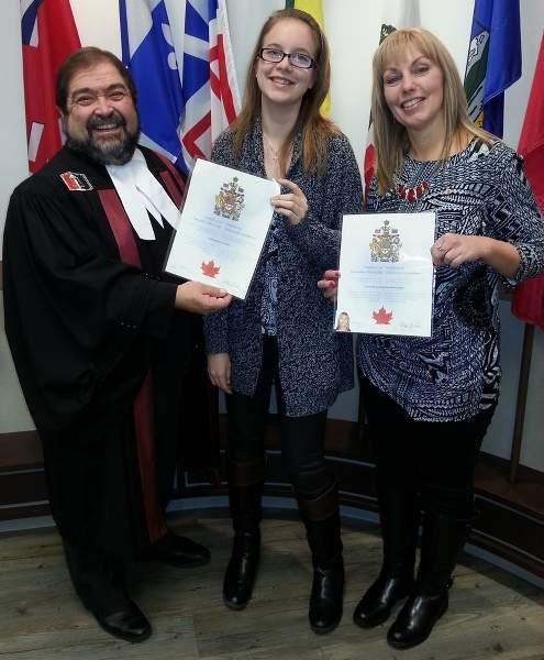 New Canadians Stephanie Rehaeuser (far right) and daughter Chiara (centre) pose with a citizenship judge after officially becoming Canadian citizens.