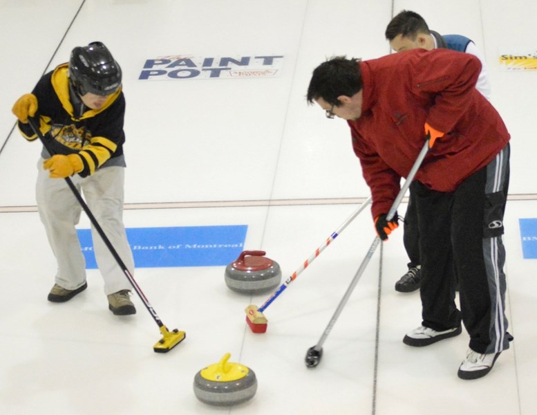 From left, Mark Mengersen, Jamie Barnett and Paul Sawka (behind Barnett) sweep during a match at the Special Olympics Bonspiel on Dec. 7 at the Olds Sportsplex.