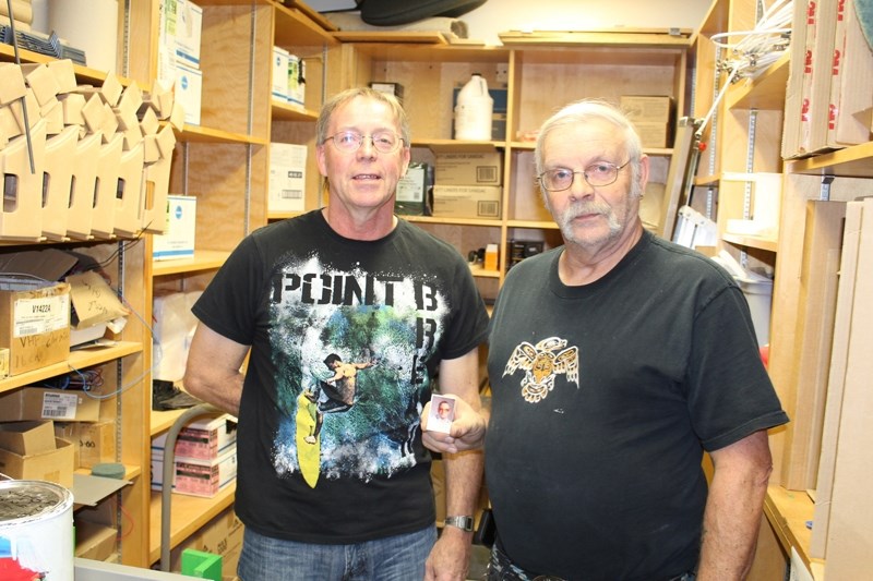 Darrel (left) and Wayne Howden (holding school photo of his dad Roy) are carrying on the family tradition of serving as custodians in the Chinook&#8217;s Edge School Division.