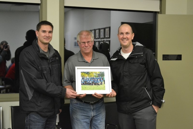 Bowden Grandview Blazers football team defensive coach Adam Neale (left) and head coach Chris Grudeski (right) present Bowden mayor Robb Stuart (centre) with a team photo. In 