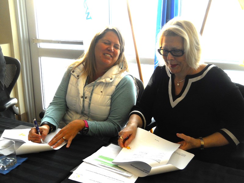 MASTER AGREEMENT SIGNED &#8211; Mountain View County deputy reeve Patricia McKean, left, and Olds mayor Judy Dahl share a smile as they sign copies of the new inter-municipal 