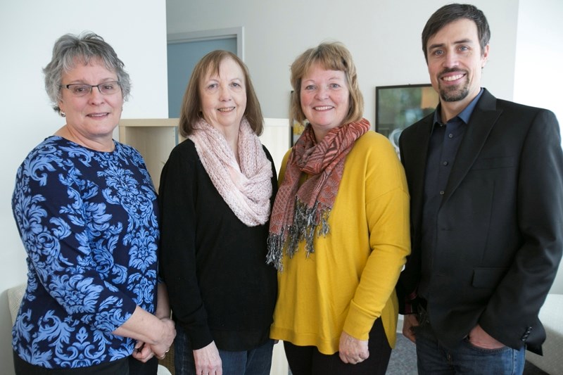 Olds Institute Legacy Fund representative Lucille Konsmo, left, and Olds Institute chairman Cody Becker, right, with Donna Erdman, chair of the Olds Historical Society,