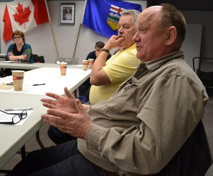 Tasty Thai owner Garnet Greipl (foreground) pitches his idea for a sidewalk cafe in front of his business while Uptowne Olds Committee chair Leon Durand, sitting beside