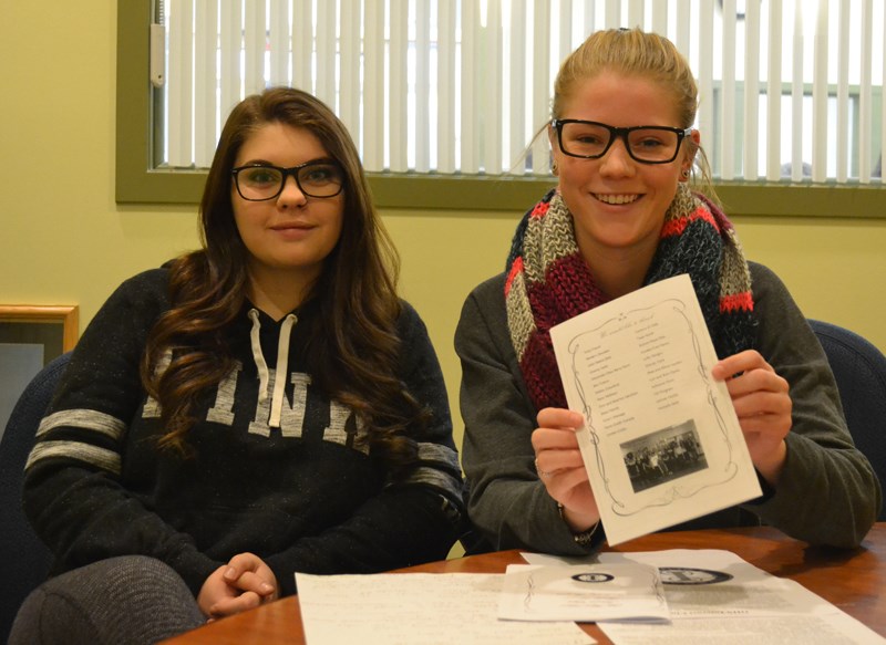 Olivia Hughes (left) and Emily Vandermeer of the Olds High School Interact Club display the back of the fundraising dinner menu where advertisers can have their names