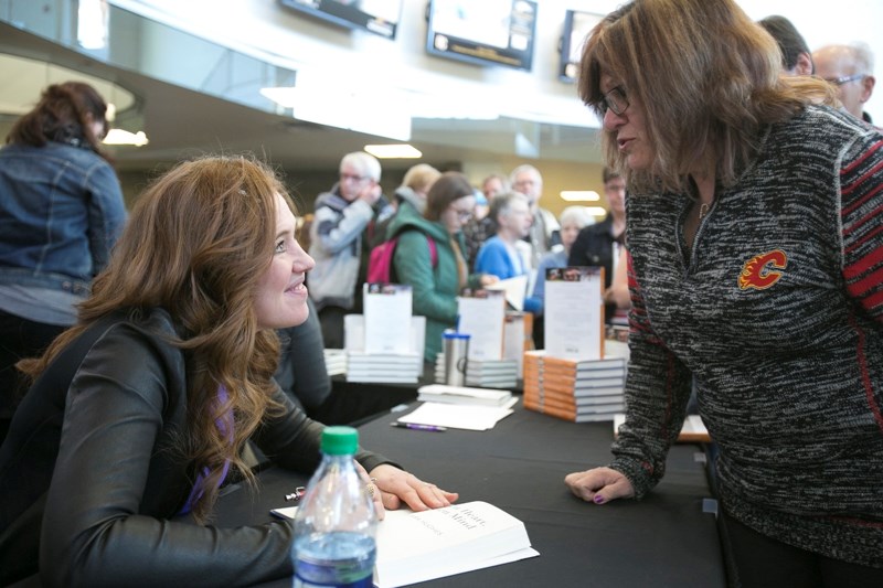 Clara Hughes signs a copy of her book for Maryse Beeney after giving her presentation at the Ralph Klein Centre.