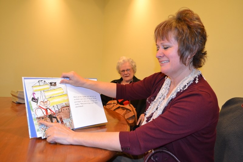 Author Corina Whyke points out some of the details in illustrations her mom, Eva Green, created for the book as Green, in the background, looks on.