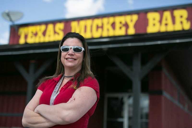 Texas Mickey bar owner Jen Casavant stands in front of her business.