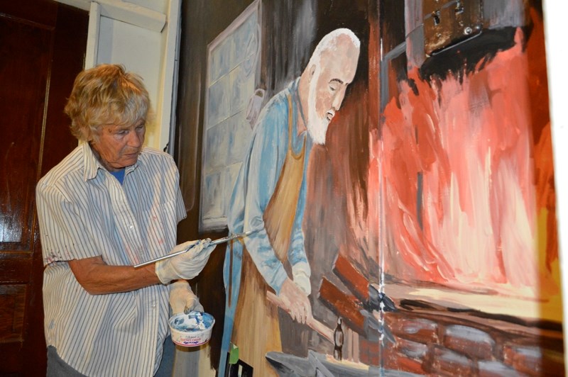Anne Burchill works on a painting of a blacksmith inside the Mountain View Museum and Archives on May 6.