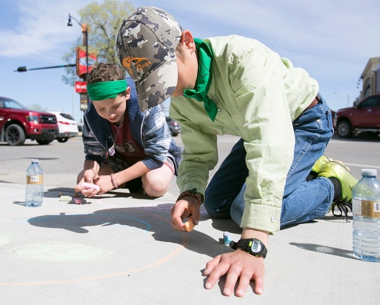 Deer Meadow Grade 6 students Phillip Perreault, left, and Kody Holmes write a message on the sidewalk.&lt;br /&gt;Noel West/MVP Staff&lt;br /&gt;Deer Meadow Grade 6 students