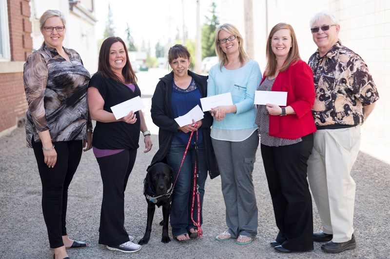 Spring Fling co-chairs Tracy Gardner (far left) and Hugh Bodmer (far right) present cheques to, from second to left: Michelle Jaffray of the Olds Gymnastics Club, Rhonda