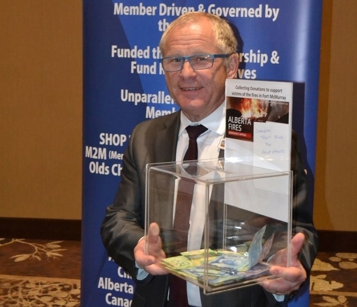 Olds and District Chamber of Commerce president Stephen Dodwell holds a container of money donated by people attending a special chamber lunch at the Pomeroy Inn &#038;