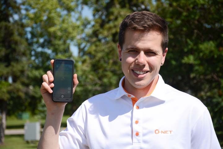 Carson Statham is holding up his phone with Pokemon Go on it at Centennial Park on Tuesday, July 26.