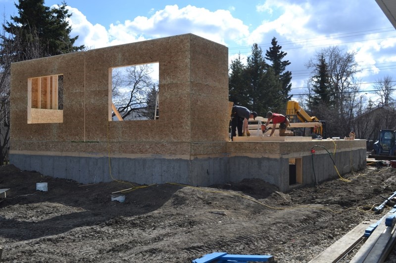 Employees work on a duplex in Olds. No permits for housing construction were issued in July.