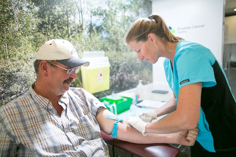 Lab technologist Brandi-Lynn Malysh prepares to draw blood from Allister Thesen during the MAN VAN&#8217;s visit to the Olds Farmers&#8217; Market.