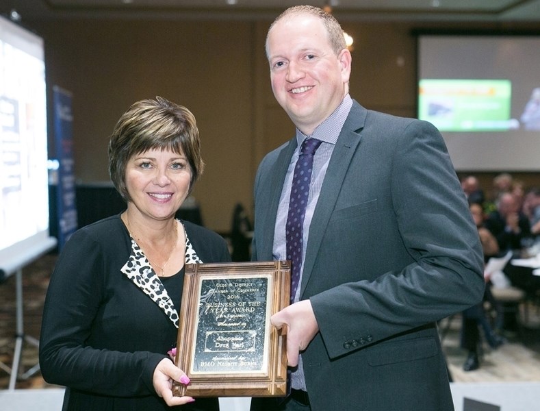 Debbie Packer, left, presents Paul Gustafson of Shoppers Drug Mart with the 2016 Business of the Year Award for firms with 16 or more employees during the Olds &#038;